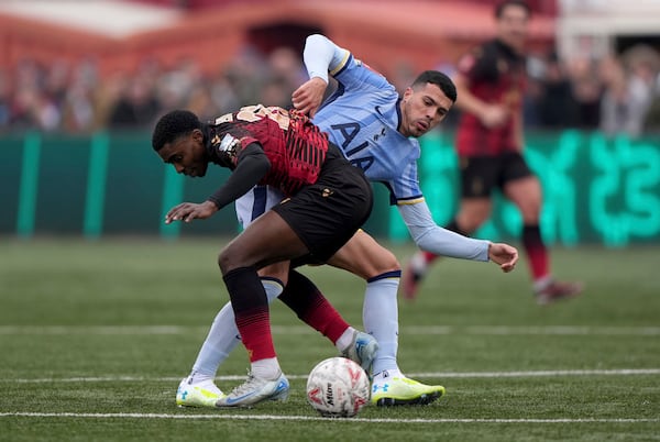 Tamworth's Beck-Ray Enoru, left, and Tottenham Hotspur's Pedro Porro battle for the ball during the English FA Cup third round match at The Lamb Ground, Tamworth, England, Sunday Jan. 12, 2025. (Joe Giddens/PA via AP)