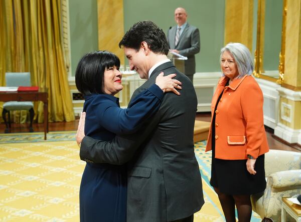 Treasury Board President Ginette Petitpas Taylor hugs Prime Minister Justin Trudeau as Gov. Gen. Mary Simon looks on during a cabinet swearing-in ceremony at Rideau Hall in Ottawa, on Friday, Dec.20, 2024.(Sean Kilpatrick /The Canadian Press via AP)