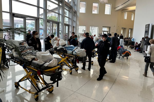 People are wheeled into an evacuation center at the Pasadena Convention Center in Pasadena, Calif., as they are evacuated due to the Eaton Fire, Wednesday, Jan. 8, 2025. (AP Photo/Ryan Pearson)