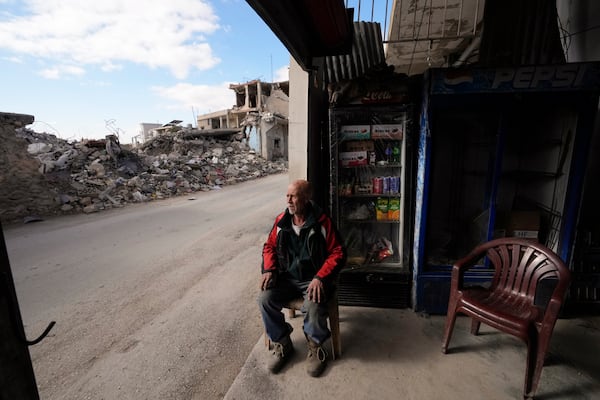 A man who was injured in Israeli airstrikes, sits in his shop near destroyed buildings in Baalbek, eastern Lebanon, Thursday, Nov. 28, 2024. (AP Photo/Hassan Ammar)