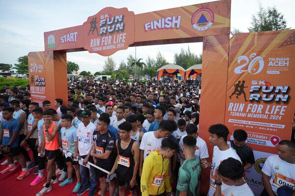 Participants prepare for the start of a 5km running event titled "Run for Life, Tsunami Memorial 2024" held to commemorate the 20th anniversary of the Indian Ocean tsunami, in Banda Aceh, Aceh province, Indonesia, Sunday, Dec. 15, 2024. (AP Photo/Achmad Ibrahim)