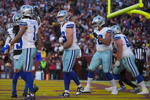 Dallas Cowboys tight end Luke Schoonmaker (86), center, celebrates after scoring a 22-yard touchdown during the second half of an NFL football game against the Washington Commanders, Sunday, Nov. 24, 2024, in Landover, Md. (AP Photo/Stephanie Scarbrough)