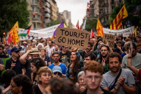 FILE - Demonstrators march shouting slogans against the Formula 1 Barcelona Fan Festival in downtown Barcelona, Spain, Wednesday, June 19, 2024, during residents protest against mass tourism. (AP Photo/Emilio Morenatti, File)