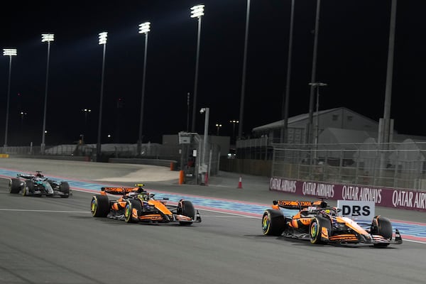 McLaren driver Oscar Piastri of Australia is about to cross the finish line followed by his teammate McLaren driver Lando Norris of Britain and Mercedes driver George Russell of Britain during sprint race at the Formula One Qatar Grand Prix, at the Lusail International Circuit in Lusail, Qatar, Saturday, Nov. 30, 2024. (AP Photo/Pool/ Altaf Qadri)