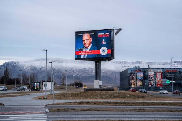 A Bilboard of the Democratic Party (Lýðræðisflokkurinn) reading "Let's limit the interest rate by law to a maximum of 4%" is backdropped by Mt. Esja covered with fresh snow, in Reykjavik, Iceland, Friday, Nov. 29, 2024. (AP Photo Marco Di Marco)