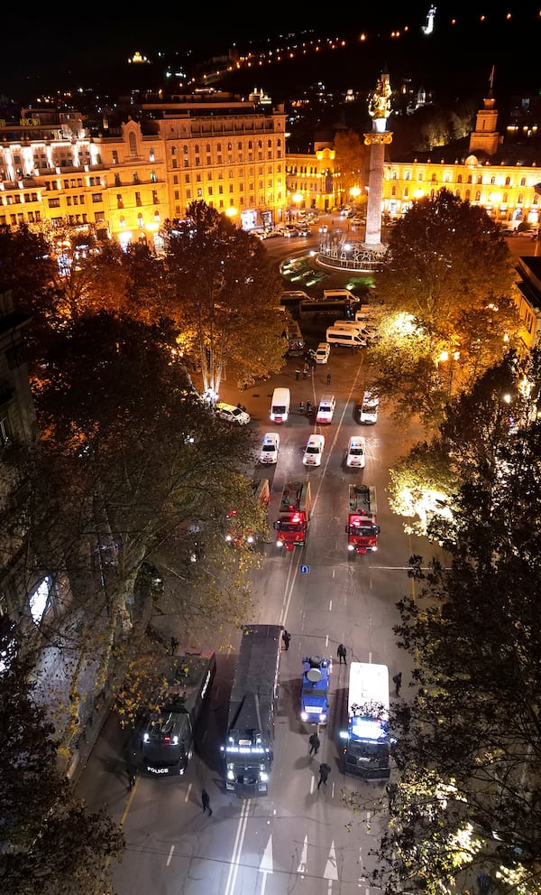 Police vehicles and ambulances parked rally outside the parliament's building where protesters gather to protest the government's decision to suspend negotiations on joining the European Union for four years in Tbilisi, Georgia, Friday, Nov. 29, 2024. (AP Photo/Zurab Tsertsvadze)