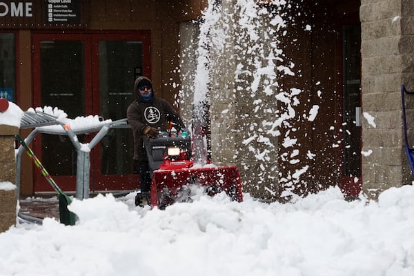 A worker clears the entrance to a building with a snow blower during a storm, Thursday, Nov. 21, 2024, at Sugar Bowl Ski Resort in Norden, Calif. (AP Photo/Brooke Hess-Homeier)