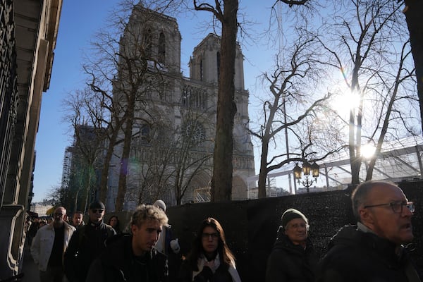 People walk by a security perimeter next to Notre-Dame cathedral, Thursday, Nov. 28, 2024 in Paris. (AP Photo/Michel Euler)