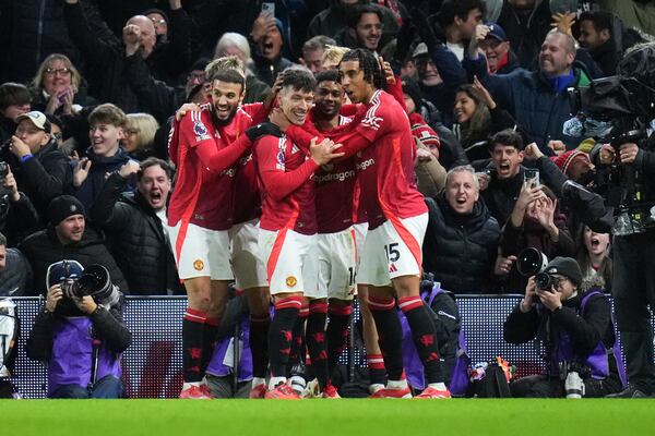 Manchester United's Lisandro Martinez, center, is congratulated after scoring his side's opening goal during the English Premier League soccer match between Fulham and Manchester United at Craven Cottage stadium in London, Sunday, Jan. 26, 2025. (AP Photo/Kirsty Wigglesworth)