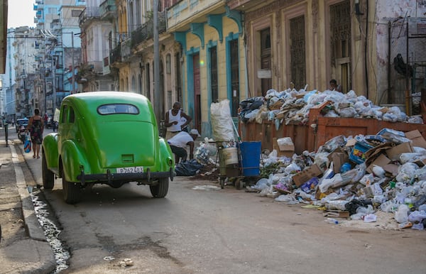 FILE - A classic American car drives past garbage in Havana, Cuba, Sept. 24, 2024. (AP Photo/Ramon Espinosa, File)