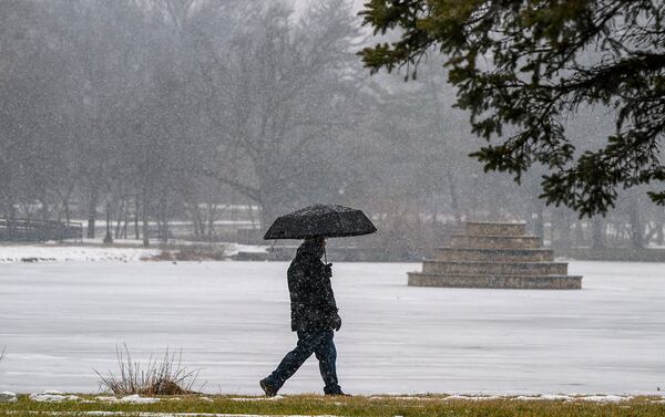 A man walks around Culler Lake in Frederick, MD during the snowfall on Sunday, Jan. 19, 2025. (Ric Dugan/The Frederick News-Post via AP)