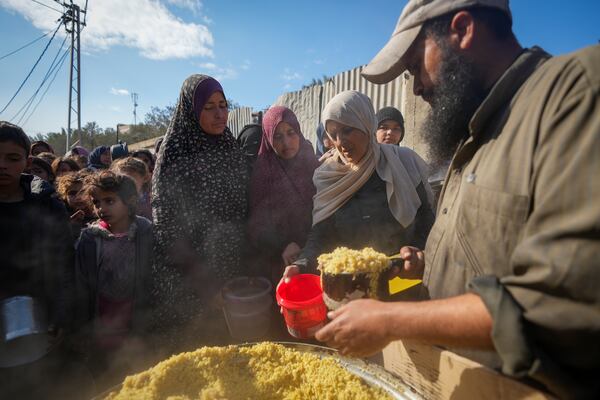 Women receive donated food at a distribution center for displaced Palestinians in Deir al-Balah, Gaza Strip, Dec. 17, 2024. (AP Photo/Abdel Kareem Hana)