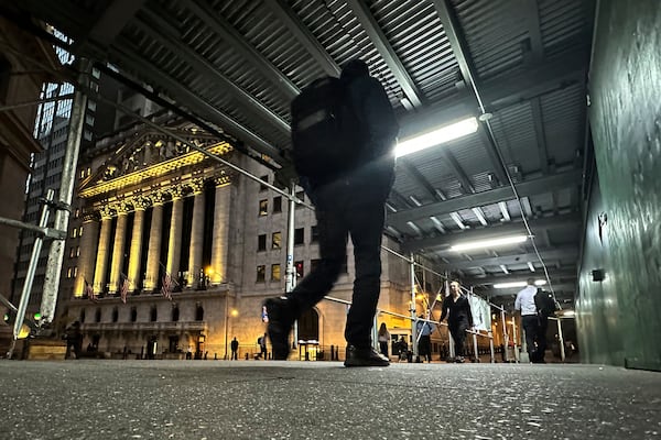 FILE - People walk under a sidewalk shed near the New York Stock Exchange on Oct. 30, 2024. (AP Photo/Peter Morgan, File)