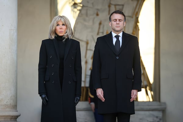 French President Emmanuel Macron and his wife Brigitte Macron stand for a minute of silence Monday, Dec. 23, 2024 at the Elysee Palace, in Paris, after Macron declared a day of national mourning for the lives lost when Cyclone Chido ripped through the Indian Ocean territory of Mayotte. (AP Photo/Thomas Padilla, Pool)