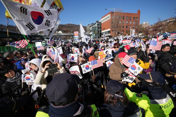 Supporters of impeached South Korean President Yoon Suk Yeol stage a rally after hearing a news that a court issued warrants to detain Yoon, near the presidential residence in Seoul, South Korea, Tuesday, Dec. 31, 2024. The letters read "Oppose Impeachment." (AP Photo/Lee Jin-man)