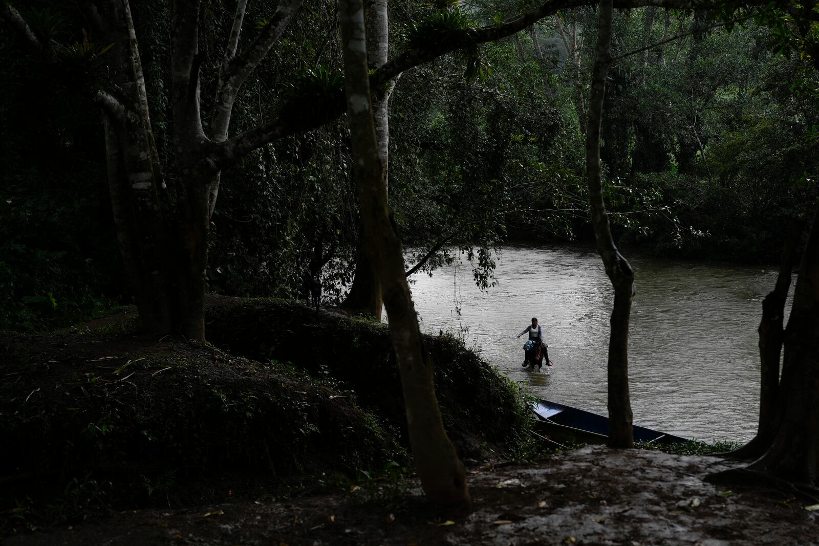 A woman rides her horse in the Indio River, which could have its flow reduced and submerge her community of Limon under a proposed plan to secure the Panama Canal’s uninterrupted operation, in Panama, Saturday, Aug. 31, 2024. (AP Photo/Matias Delacroix)