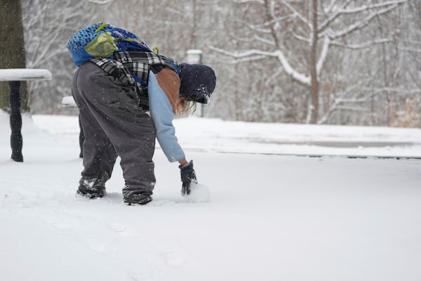 Tiffany Prichard rolls a snow ball to build a snowman Friday, Jan 10, 2025, in Nashville, Tenn. (AP Photo/George Walker IV)