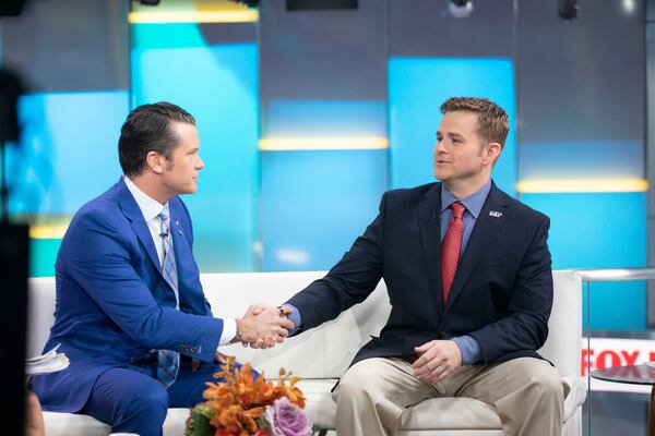 FILE - Pete Hegseth, left, with Fox News, shakes hands with Army 1st Lt. Clint Lorance during his appearance on "Fox & Friends," Nov. 18, 2019, in New York. President Donald Trump issued a full pardon Friday, Nov. 15 for Lorance, who had been convicted of murder for ordering his soldiers to fire upon three unarmed Afghan men in July 2012, killing two. (AP Photo/Mark Lennihan, File)