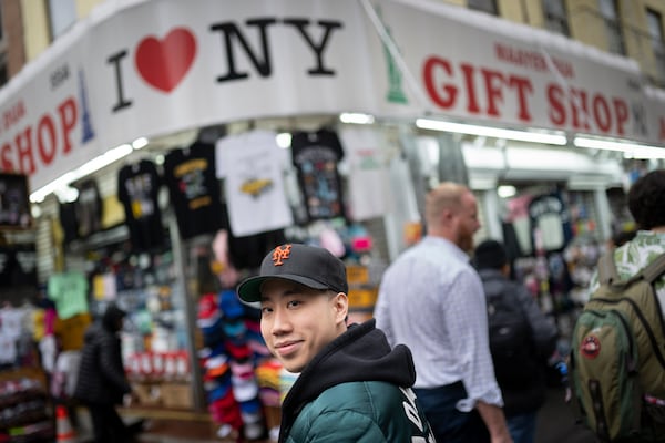 Karho Leung, 33, one of the founders of 12 Pell, a local barbershop, walks along Mott Street in Manhattan's Chinatown neighborhood, Thursday, Jan. 25, 2024, in New York. (AP Photo/John Minchillo)