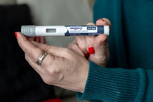 FILE - A woman holds up a dosage of Wegovy, a drug used for weight loss, at her home in Front Royal, Va., on March 1, 2024. (AP Photo/Amanda Andrade-Rhoades, File)