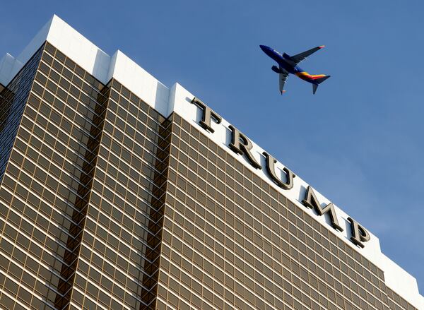 An airplane flies over Trump International Hotel, on Thursday, Jan. 2, 2025, in Las Vegas. (Bizuayehu Tesfaye/Las Vegas Review-Journal via AP)