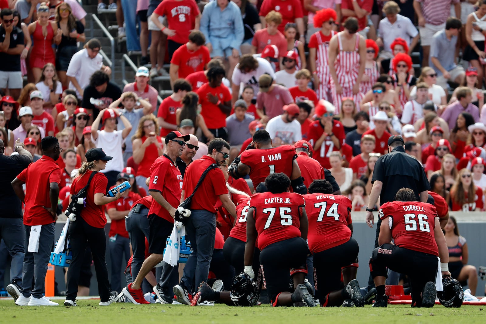 North Carolina State players take a knee as quarterback Grayson McCall (2) is taken from the field after suffering an injury during the first half of an NCAA college football game against Wake Forest in Raleigh, N.C., Saturday, Oct. 5, 2024. (AP Photo/Karl B DeBlaker)