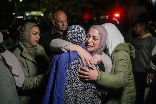 A female Palestinian prisoner, facing the camera, is greeted after disembarking from a bus following her release from an Israeli prison, in the West Bank city of Beitunia, early Monday, Jan. 20, 2025. (AP Photo/Leo Correa)