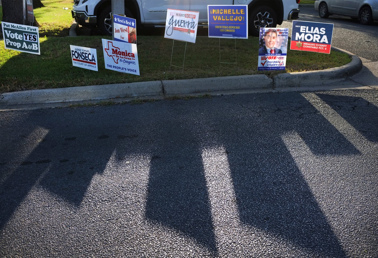 FILE - Campaign signs for candidates cast a shadow on the street during early voting at Lark Library, Oct. 21, 2024, in McAllen, Texas. (Delcia Lopez/The Monitor via AP, File)