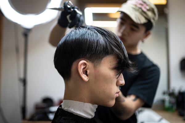 Barbers work on their clients at 12 Pell, a local barbershop in Manhattan's Chinatown, Thursday, Jan. 25, 2024, in New York. (AP Photo/John Minchillo)