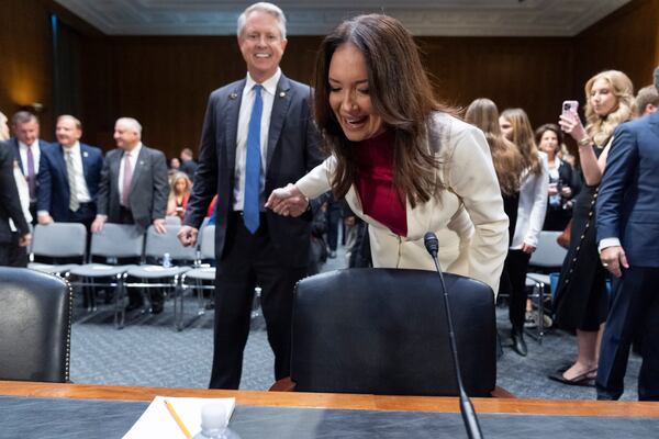 Sen. Roger Marshall, R-Kan., left, shows Brooke Rollins a pin he left her ahead of a attends a Senate Agriculture, Nutrition, and Forestry Committee hearing on her nomination for Secretary of Agriculture, Thursday, Jan. 23, 2025, in Washington. (AP Photo/Jacquelyn Martin)