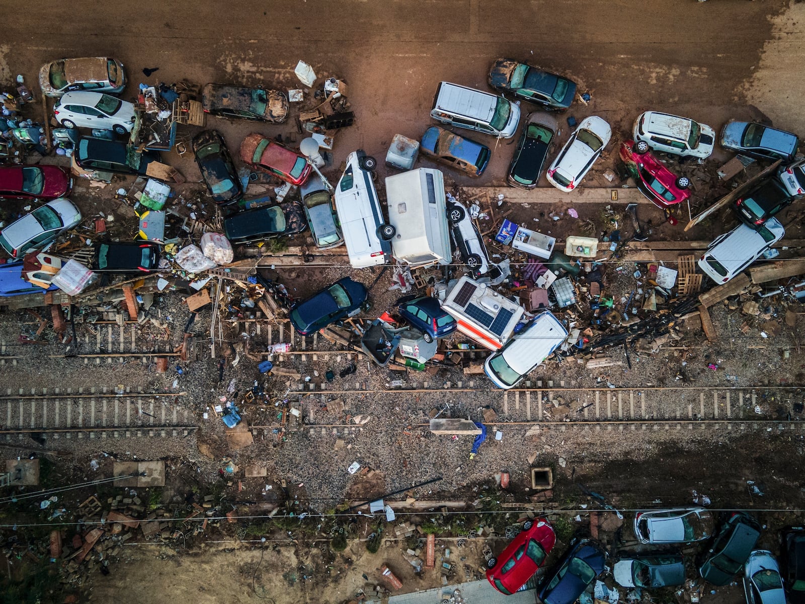 Vehicles pile up on the train tracks in the aftermath of flooding caused by late Tuesday and early Wednesday storm that left hundreds dead or missing in Alfafar, Valencia region, Spain, Saturday, Nov. 2, 2024.(AP Photo/Angel Garcia)