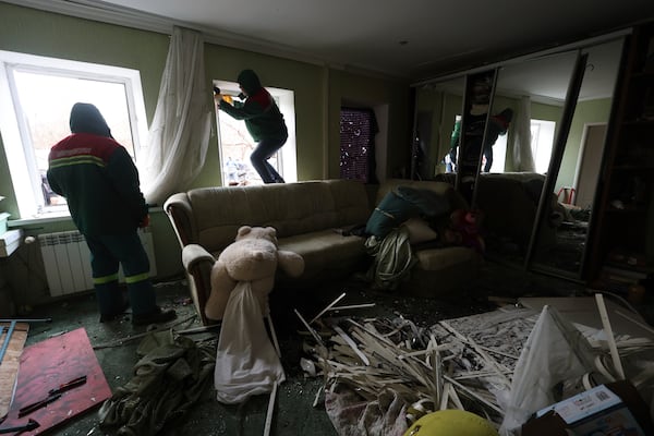 Municipal workers cover windows inside a house damaged by a Russian drone strike on a residential neighbourhood in Zaporizhzhia, Ukraine, Monday Nov. 25, 2024. (AP Photo/Kateryna Klochko)