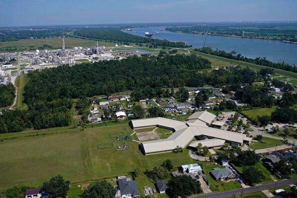 FILE - The Fifth Ward Elementary School and residential neighborhoods sit near the Denka Performance Elastomer Plant, back left, in Reserve, La., Sept. 23, 2022. (AP Photo/Gerald Herbert, File)