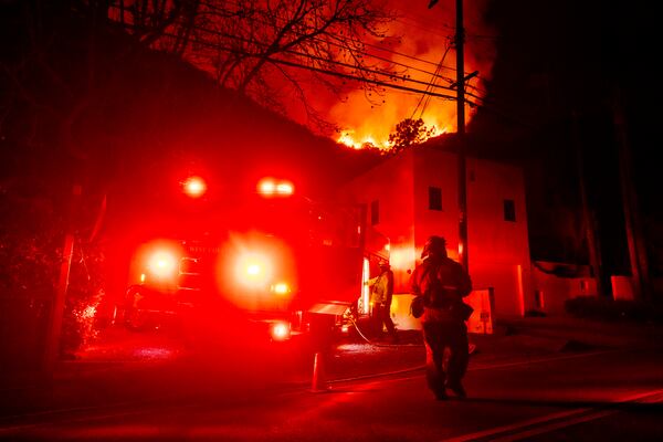 Firefighters set up to defend houses threatened by the Palisades Fire in Mandeville Canyon, Friday, Jan. 10, 2025, in Los Angeles. (AP Photo/Etienne Laurent)