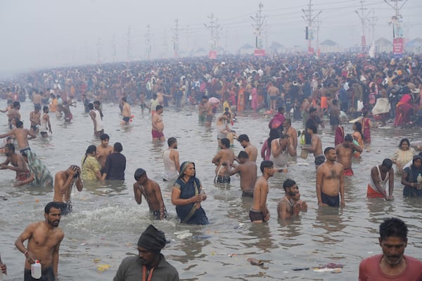 Hindu devotees take a holy dip by the banks of the Sangam, the confluence of the Ganges, the Yamuna and the mythical Saraswati rivers, on "Mauni Amavasya" or new moon day during the Maha Kumbh festival in Prayagraj, Uttar Pradesh, India, Wednesday, Jan. 29, 2025. (AP Photo/Deepak Sharma)