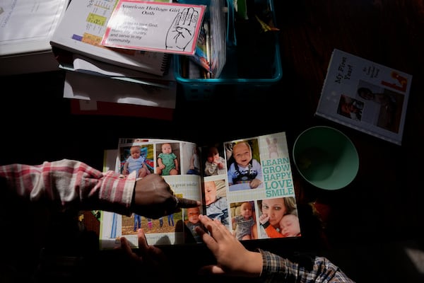 Isaac Young, 5, right, and his big sister Gianna Young, 7, look at his one-year baby book during a homeschool break in the dining room of their Sunbury, Ohio, home on Tuesday, Nov. 12, 2024. (AP Photo/Carolyn Kaster)