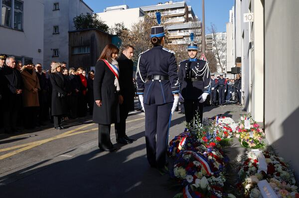 French President Emmanuel Macron, and Paris Mayor Anne Hidalgo, center left, attend a commemoration marking 10 years since an Islamist attack on the Charlie Hebdo satirical newspaper and the Hypercacher jewish supermarket, outside the weekly's former offices in Paris Tuesday Jan. 7, 2025. (Ludovic Marin, Pool via AP)