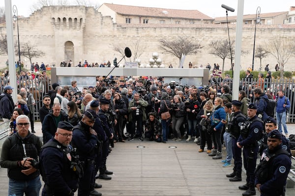 Journalists and police officers stand by while waiting for Gisele Pelicot to come out outside the Avignon courthouse, southern France, Thursday, Dec. 19, 2024. (AP Photo/Lewis Joly)