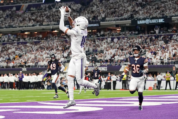 Minnesota Vikings wide receiver Justin Jefferson (18) catches a 7-yard touchdown pass in front of Chicago Bears safety Jonathan Owens (36) during the first half of an NFL football game, Monday, Dec. 16, 2024, in Minneapolis. (AP Photo/Abbie Parr)