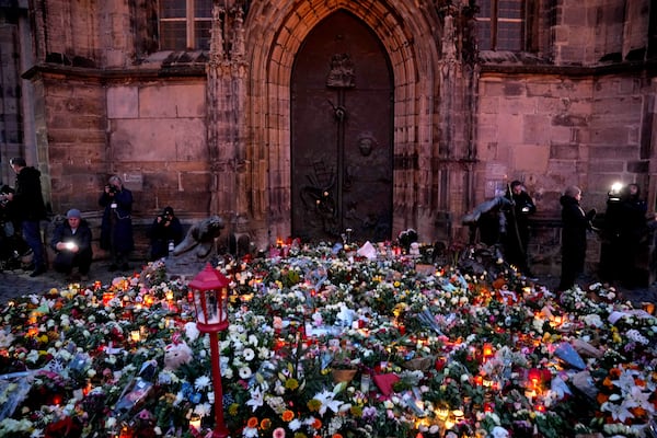 Flowers and candles are placed outside St. John's Church as a memorial site near a Christmas Market, where a car drove into a crowd on Friday evening, in Magdeburg, Germany, Saturday, Dec. 21, 2024. (AP Photo/Ebrahim Noorozi)