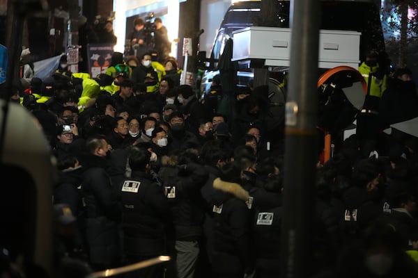 Police officers try to enter the gate of the presidential residence in Seoul, South Korea, Wednesday, Jan. 15, 2025. (AP Photo/Lee Jin-man)