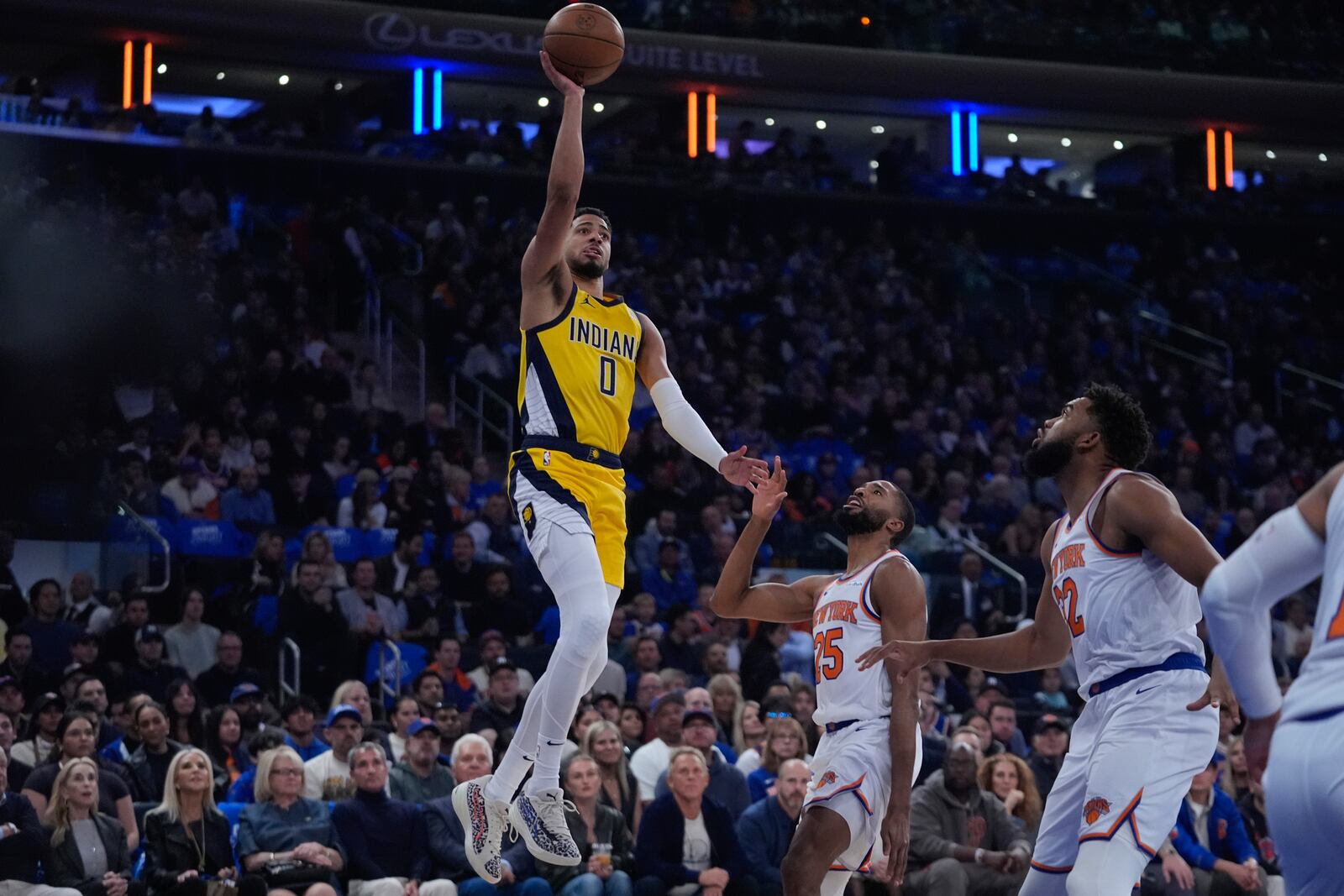 Indiana Pacers' Tyrese Haliburton (0) goes up to shoot over New York Knicks' Mikal Bridges (25) and Karl-Anthony Towns (32) during the first half of an NBA basketball game Friday, Oct. 25, 2024, in New York. (AP Photo/Frank Franklin II)