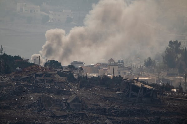 Smoke rise next to damaged buildings on an area of a village in southern Lebanon, as seen from the Kibbutz Manara, northern Israel, Thursday, Nov. 28, 2024. (AP Photo/Leo Correa)