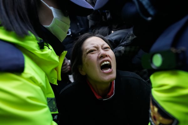 Police officers escort away a supporter of impeached South Korean President Yoon Suk Yeol as Yoon faces potential arrest after a court on Tuesday approved a warrant for his arrest, near the presidential residence in Seoul, South Korea, Thursday, Jan. 2, 2025. (AP Photo/Ahn Young-joon)