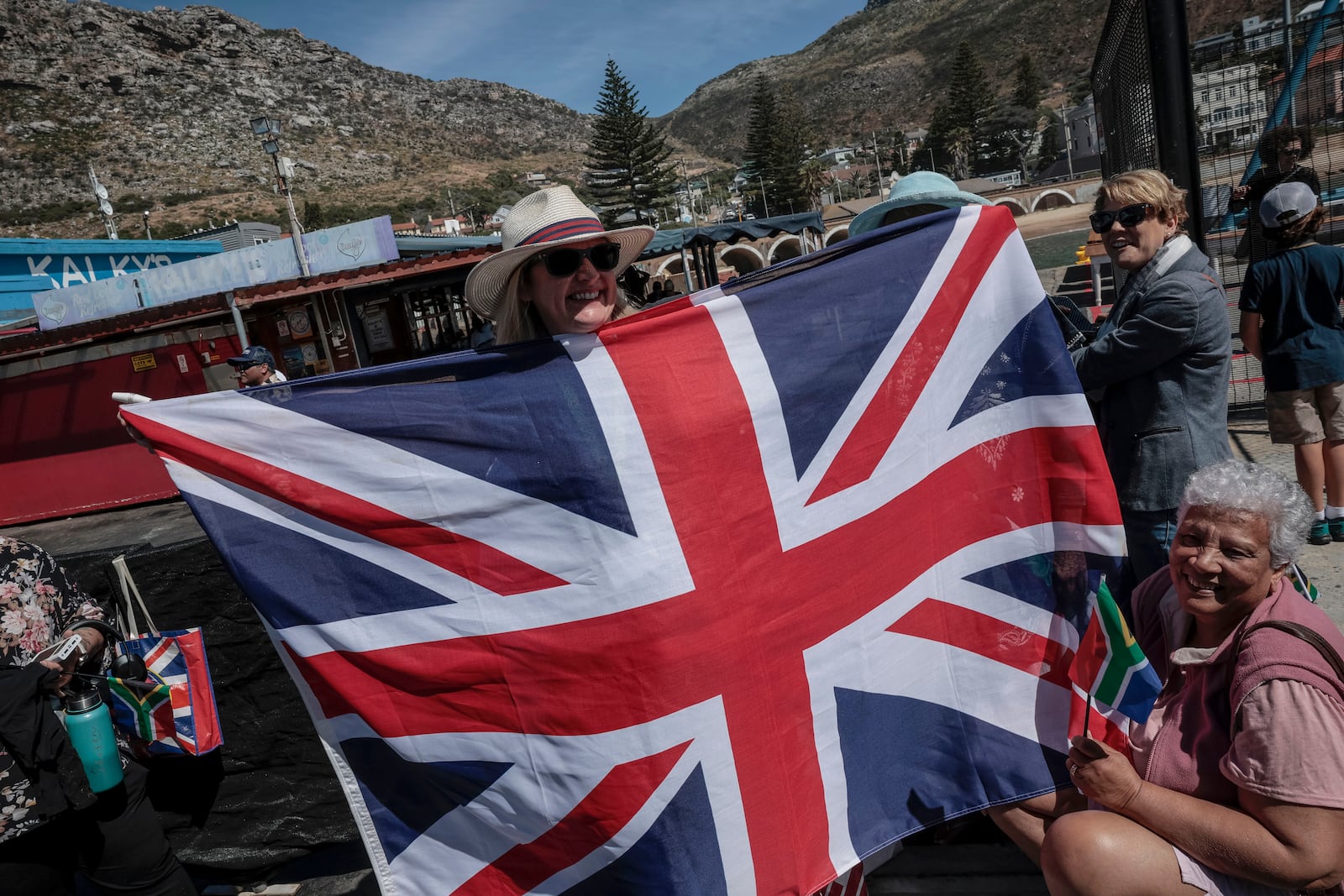 Well-wishers hold British and South African flags as they wait for Britain's Prince William, at Kalk Bay Harbour, near Cape Town, Thursday, Nov. 7, 2024. (Gianluigi Guercia/Pool Photo via AP)