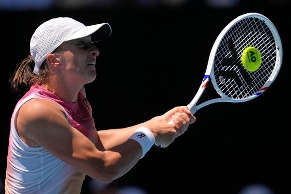 Iga Swiatek of Poland plays a backhand return to Emma Navarro of the U.S. during their quarterfinal match at the Australian Open tennis championship in Melbourne, Australia, Wednesday, Jan. 22, 2025. (AP Photo/Asanka Brendon Ratnayake)