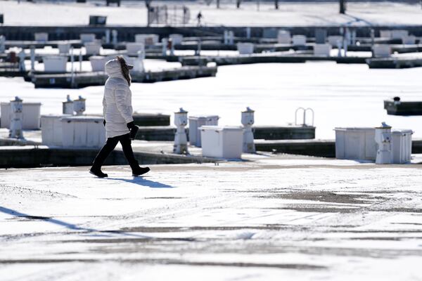 A pedestrian bundles up as she walks along the Montrose Harbor during cold weather in Chicago, Thursday, Jan. 23, 2025. (AP Photo/Nam Y. Huh)