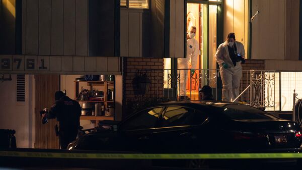 Police investigate a crime scene where they say multiple family members were found dead inside a home in West Valley City, Utah, Tuesday Dec. 17, 2024. (Scott G. Winterton/The Deseret News via AP)