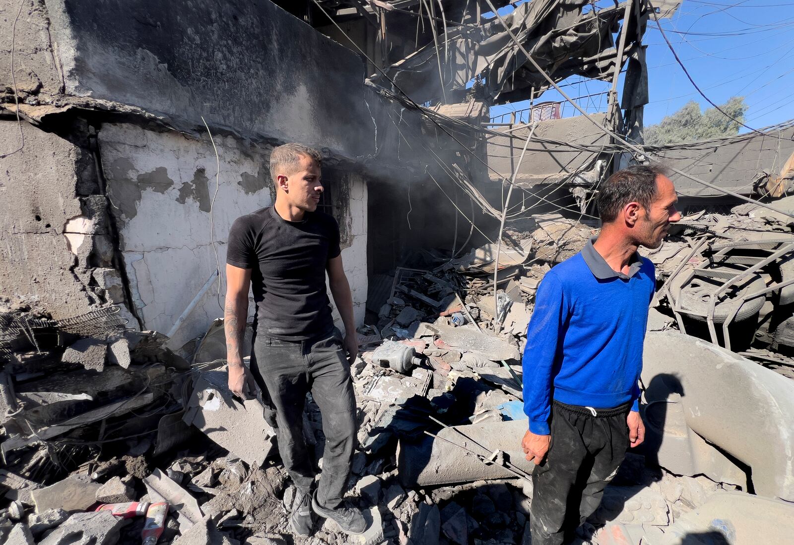 People stand on the rubble of a destroyed house that was hit Monday night by Israeli airstrikes, at a popular neighbourhood south of Beirut, Lebanon, Tuesday, Oct. 22, 2024. (AP Photo/Hussein Malla)