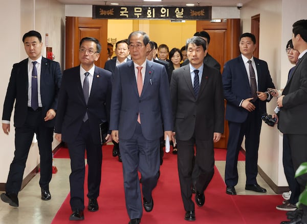 South Korean Prime Minister Han Duck-soo, center, and other ministers leave after a meeting at the government complex in Seoul, South Korea, Wednesday, Dec. 4, 2024. (Choi Jae-gu/Yonhap via AP)